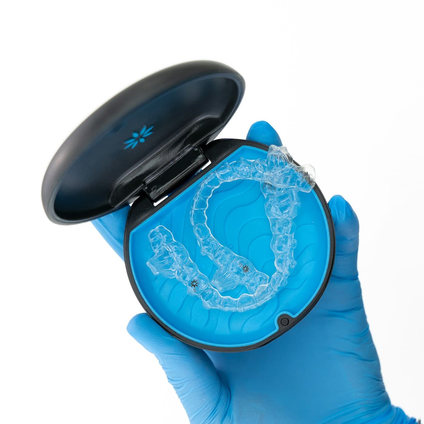 Clear aligner tray held in a gloved hand